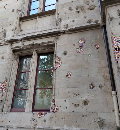 Hier sieht man die Fassade des Palais de Justice in Rouen. Die Spuren des Zweiten Weltkriegs sind unübersehbar und wurden hier künstlerisch durch Legosteine aufgearbeitet.