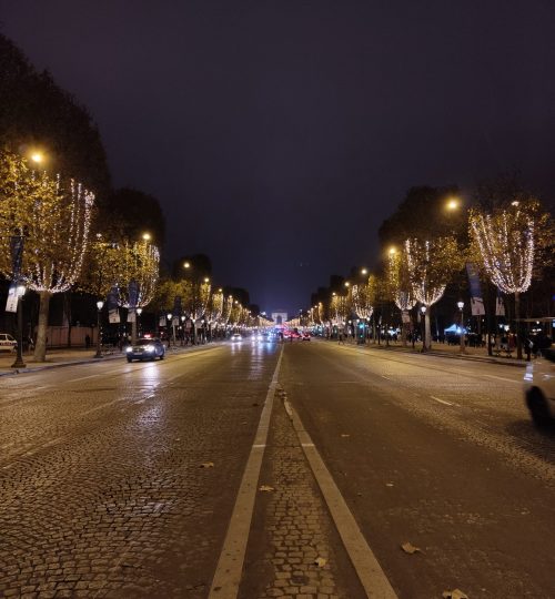 Ein Blick auf die weihnachtlich geschmückte Champs-Élysées am Abend.