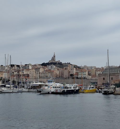 Ein kleines Stück weiter bietet sich einem dieser Blick auf den alten Hafen. Im Hintergrund befindet sich die Basilique Notre-Dame de la Garde.